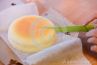 Japanese Cheesecake cut by green knife in opened paper box. Soft and sweet Stock Photo