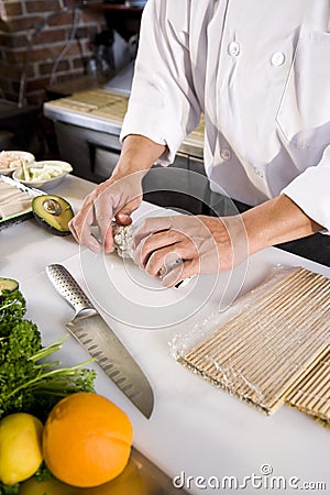 Japanese chef in restaurant making sushi roll Stock Photo