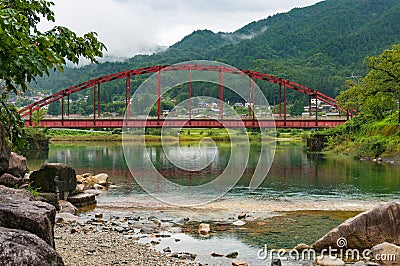 Japanese countryside landscape with bright red bridge over Kiso Stock Photo