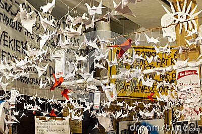 Japanese folded Origami cranes hanging on with strings. Hundreds handmade paper birds isolated with copy space. 1000 Editorial Stock Photo