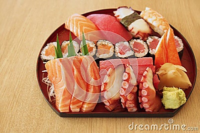 Japanese food sashimi raw sliced fish, octopus, etc. and sushi set served with fresh wasabi paste and pickled ginger on light Stock Photo