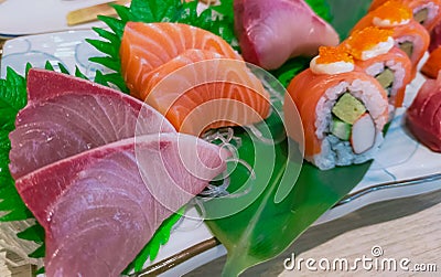 Japanese food set served on white plate. Salmon sushi and sashimi on restaurant table. Fresh raw fish meat sliced and Japan Stock Photo