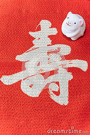 A Japanese greeting card with a cute rat figurine for the 2020 year of the mouse on a red cloth Stock Photo
