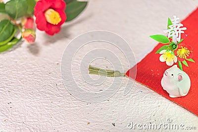 A Japanese greeting card with a Tsubaki flower also called the winter rose and a cute rat figurine for the 2020 year of the mouse Stock Photo