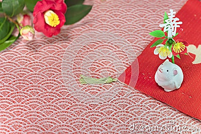 A Japanese greeting card with a Tsubaki flower also called the winter rose and a cute rat figurine for the 2020 year of the mouse Stock Photo