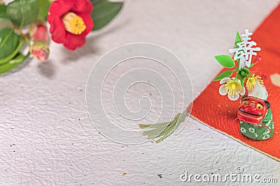 A Japanese greeting card with a Tsubaki flower also called the winter rose and a folklore animal figurine depicting Shishimai lion Stock Photo