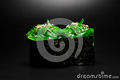 Japanese gunkan sushi with chukka and sesame seeds wrapped in nori seaweed on dark background. Stock Photo