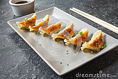 Japanese gyoza or dumplings snack with soy sauce on black stone background Stock Photo