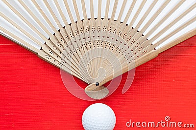 Japanese hand fan made and golf balls on the red table Stock Photo