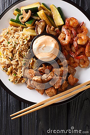 Japanese hibachi lunch made of fried rice, shrimp, steak and vegetables close-up on the table. Vertical top view Stock Photo