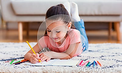 Japanese Kid Girl Drawing Using Pencils Lying On Floor Indoor Stock Photo