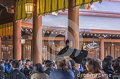 Japanese male in kimono holding a fan during a traditional kagura dance helds in the Meiji shrine. Editorial Stock Photo
