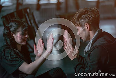 Japanese man and a Caucasian woman sit on the floor in the room and play with their hands Stock Photo