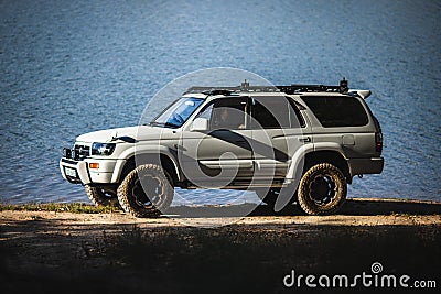 Japanese offroad used white car Toyota Hilux Surf on the lake Editorial Stock Photo