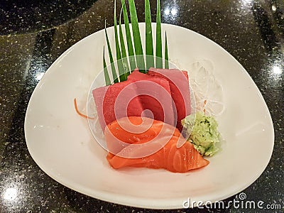 Japanese raw fish on white plate and marble black table. Also known as Sashimi. Stock Photo