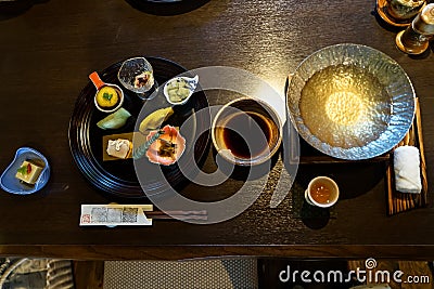 Japanese ryokan kaiseki dinner appetizer including hors d`oeuvres dishes, hot pot preparation, soy sauce bowl, liquor cup Stock Photo