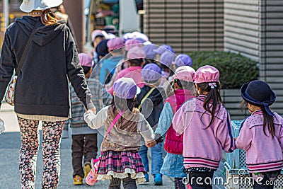 Japanese schoolchildren in coloured caps. Editorial Stock Photo