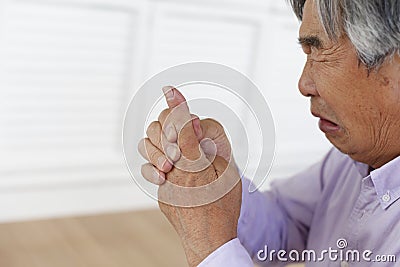 Japanese senior suffering from finger joint pain Stock Photo