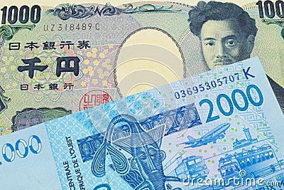 A Japanese thousand yen note paired with a blue, two thousand West African franc bank note. Stock Photo