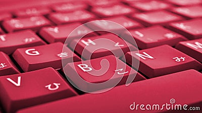 Japanese typing. Laptop keyboard closeup. Symbols on buttons of hiragana. Bright red tinted computer wallpaper or background. Stock Photo