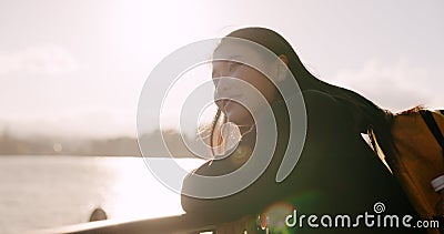 Japanese woman, lake and backpack with thinking, smile and sunrise on adventure, trip or vacation. Girl, person and Stock Photo