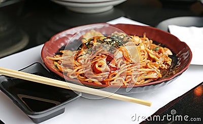 Japanese yakisoba noodles in brown ceramic plate on the black table Stock Photo