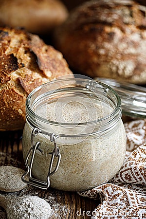 A jar with active rye sourdough for baking bread on a wooden table Stock Photo
