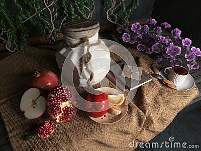 Jar,apples,pomegranate,coffe cup with books and orange on canvas drapery conceptual still-life Stock Photo
