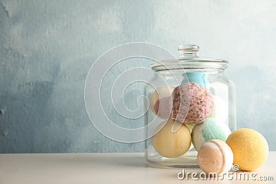 Jar with colorful bath bombs on table Stock Photo