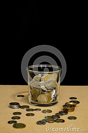 jar of glass full of mexican coins and money dropped Stock Photo