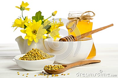 The jar of honey near two bowls, one with of pollen Stock Photo