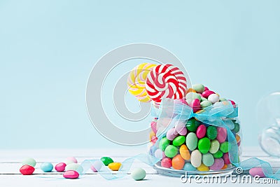 Jar staffed sweet colorful candy against turquoise background. Gifts for Birthday party. Stock Photo