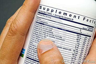 Jar with supplement facts of multivitamins in woman hands Stock Photo