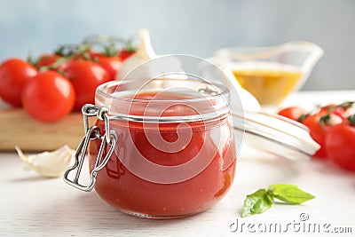 Jar of tasty tomato sauce on wooden table Stock Photo