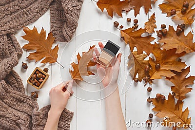 Jar with a tonal cream and oak autumn leaf in the woman`s hands. Top view. Natural beauty cosmetics concept. Autumn Stock Photo