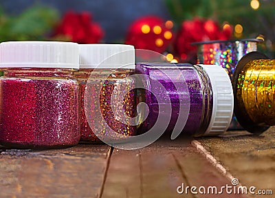 Jars, bottles full of shiny rhinestones, sparkles, confetti on wooden background Stock Photo