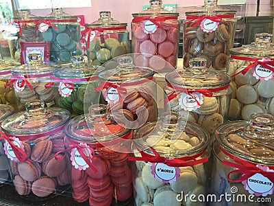 Jars of colorful macaroon cakes on display in store front Stock Photo