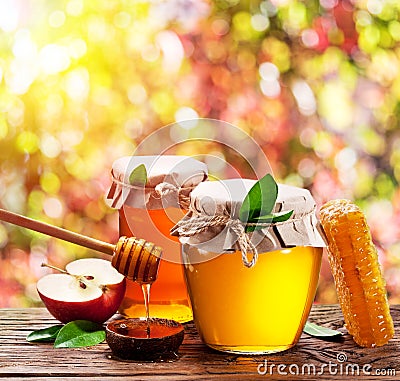 Jars full of fresh honey and honeycombs. Colorful nature background Stock Photo