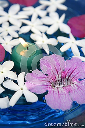 Jasmine, and pink Asarina, candles and blue water Stock Photo