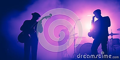 Jazz Band silhouette unrecognizable on stage. Violet background, smoke, concert spotlights Stock Photo