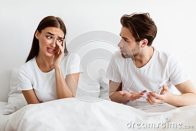 Jealous Husband Showing Cheating Wife Cellphone Suspecting Affair In Bedroom Stock Photo