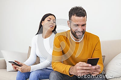 Jealous suspicious mad wife arguing with obsessed husband holding phone texting cheating on cellphone, distrustful girlfriend Stock Photo