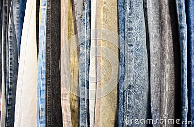 Jeans in blue and various colors arranged in vertical rows Stock Photo