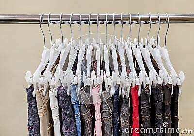 Jeans hanging in row on hanger Stock Photo