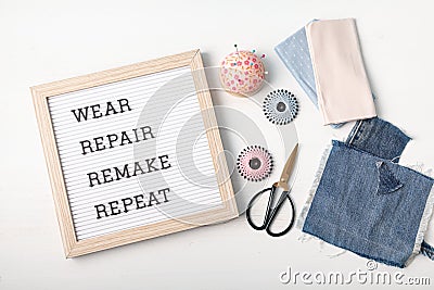Jeans with letter board and text wear, repair, remake, repeat Stock Photo