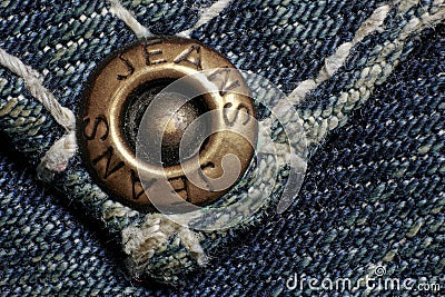 Jeans rivet, old dirty jeans, macro photo. Fashion jeans button. Sign JEANS JEANS on bronze part of button. Blue denim Stock Photo