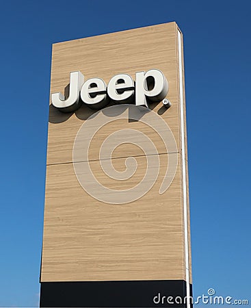 Jeep logo on wood background outside the car dealership of the area. It is the symbol of the american automaker, today a division Editorial Stock Photo