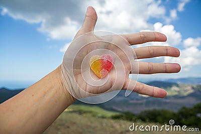 Jelly sweet candy heart on outstretched palm Stock Photo