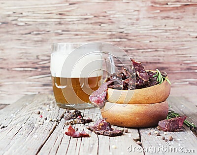 Jerked meat, cow, deer, wild beast or biltong in wooden bowls on a rustic table, selective focus Stock Photo