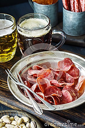 Jerky pork chips on vintage plate with beer on table Stock Photo